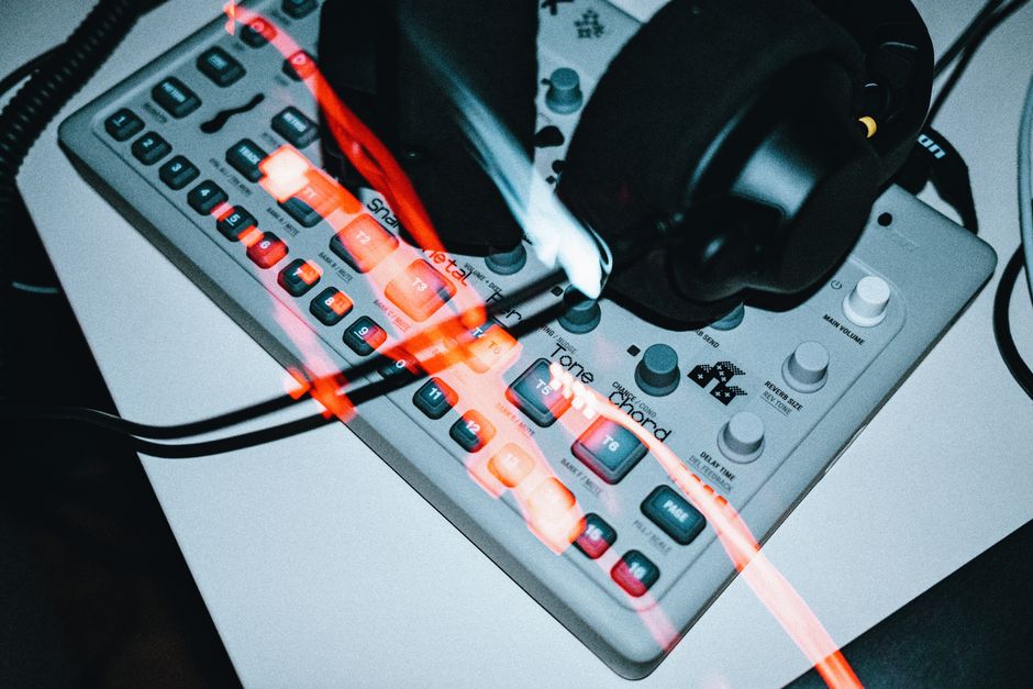 Un primer plano de equipo de audio vintage con auriculares mostrando botones iluminados.