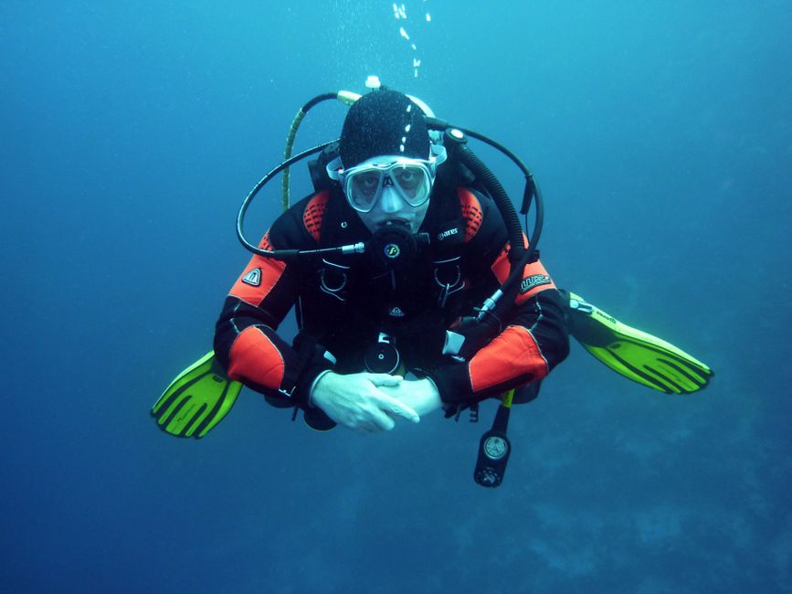 Un buceador en un traje seco explorando las profundidades del océano con equipo completo de scuba.