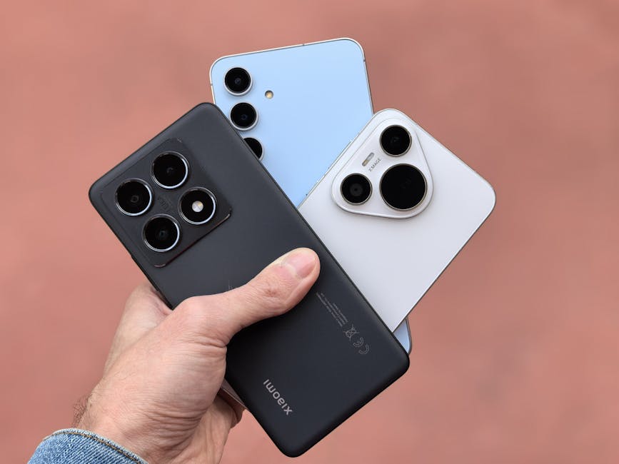 Primer plano de una mano que sostiene tres teléfonos inteligentes modernos con cámaras a la vista, mostrando un diseño contemporáneo.