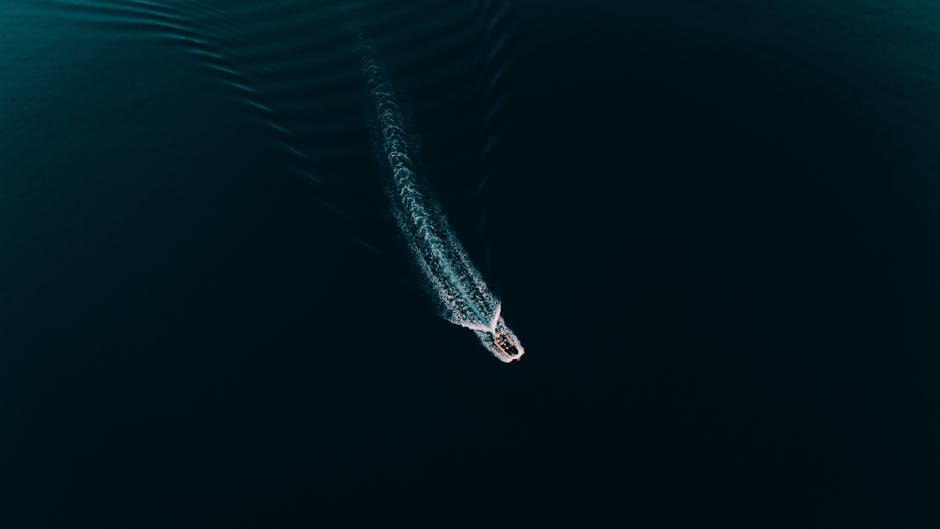 Toma aérea de una lancha rápida creando ondas en las tranquilas aguas azules en Demre, Antalya.
