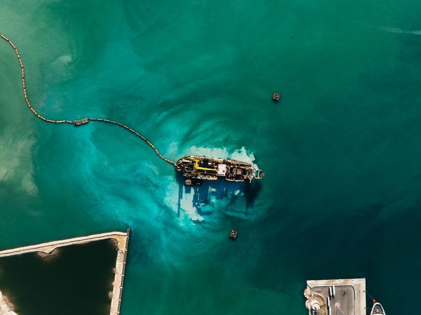 Vista de dron de un barco en aguas turquesa cerca de Bari, Italia. Colores vibrantes y perspectiva única.