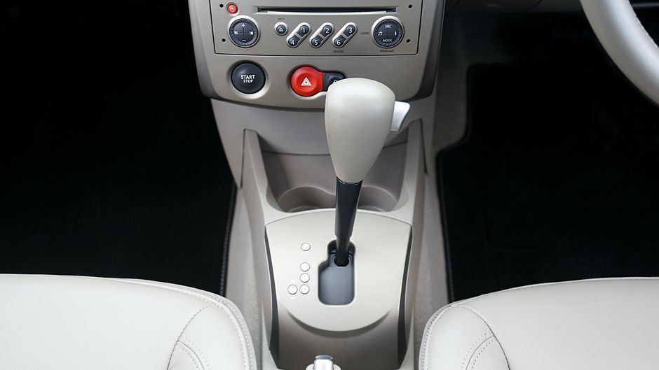 Vista en primer plano del console central de un coche con palanca de cambios y botones de control.