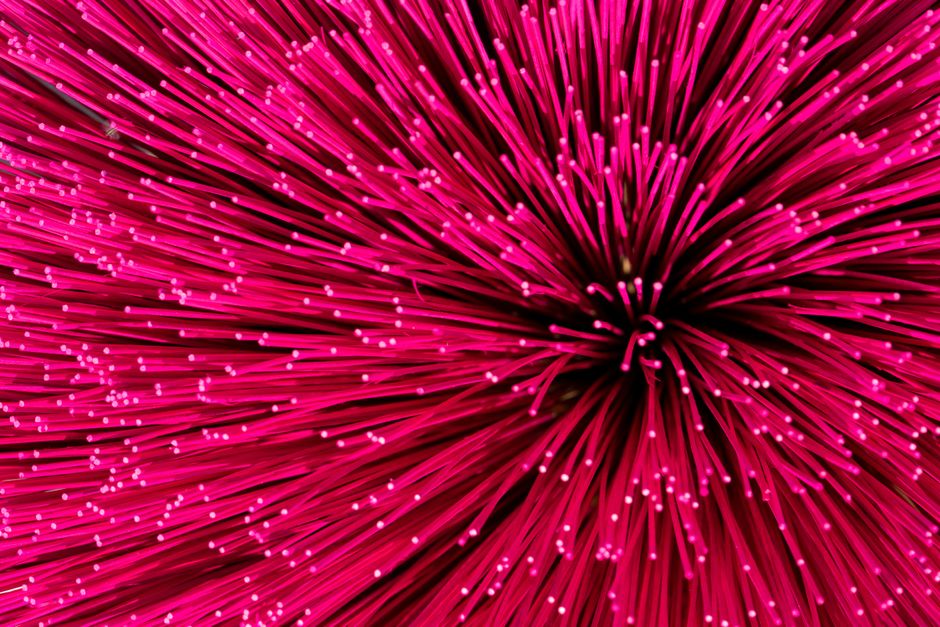 Primer plano abstracto de varillas de incienso de color rosa vibrante dispuestas en un patrón radial.