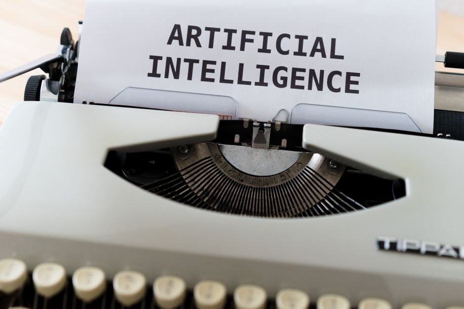 Máquina de escribir con una hoja que muestra el texto «ARTIFICIAL INTELLIGENCE».