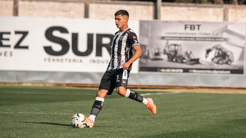 Joven futbolista en acción sobre el terreno de juego durante un partido diurno.