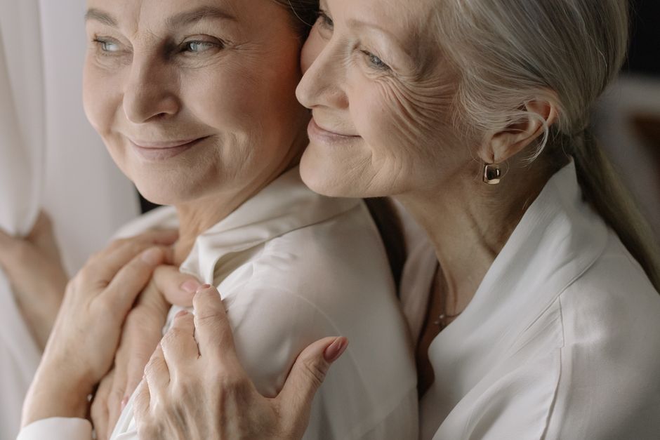 Mujeres ancianas compartiendo un momento tierno, reflejando amor y unidad.
