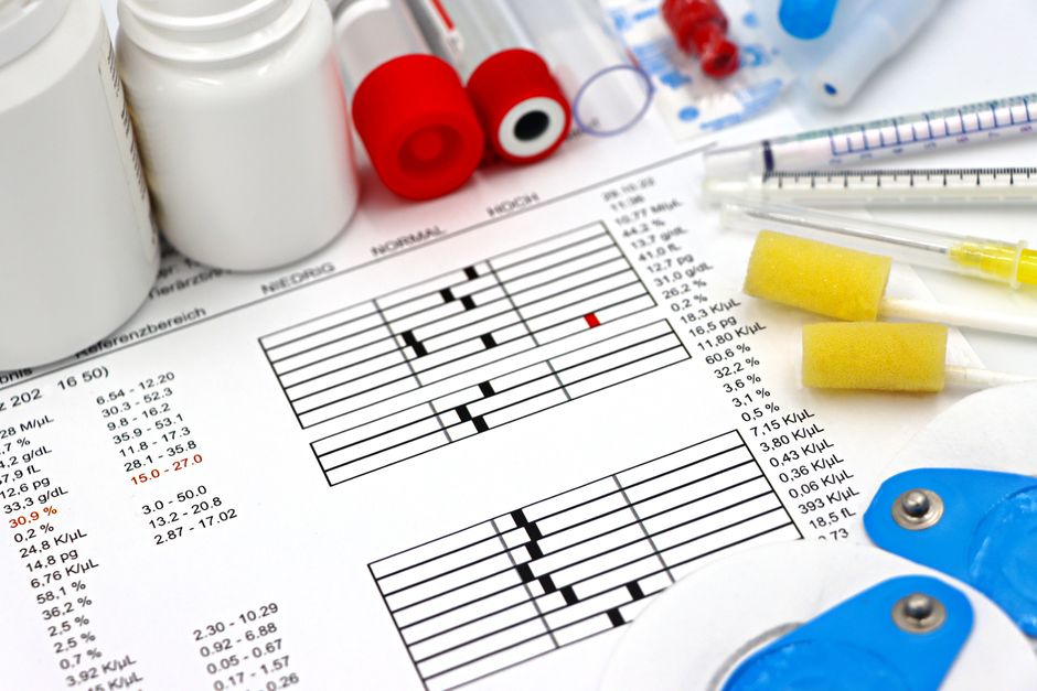 Disposición de equipos médicos, pruebas de laboratorio y datos de salud en una mesa clínica.