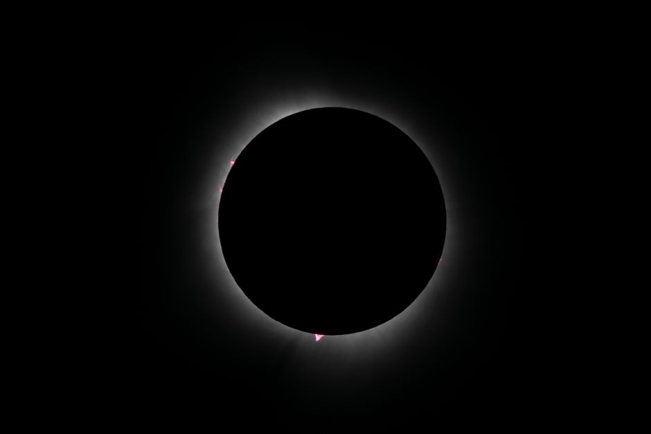 Captura de un eclipse solar anular con corona resplandeciente, mostrando la belleza celestial en un cielo oscuro.