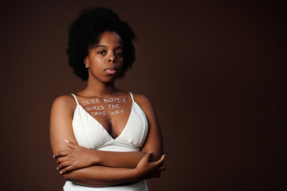 Retrato de una mujer con cabello afro abogando por la igualdad de género con un lema en texto.