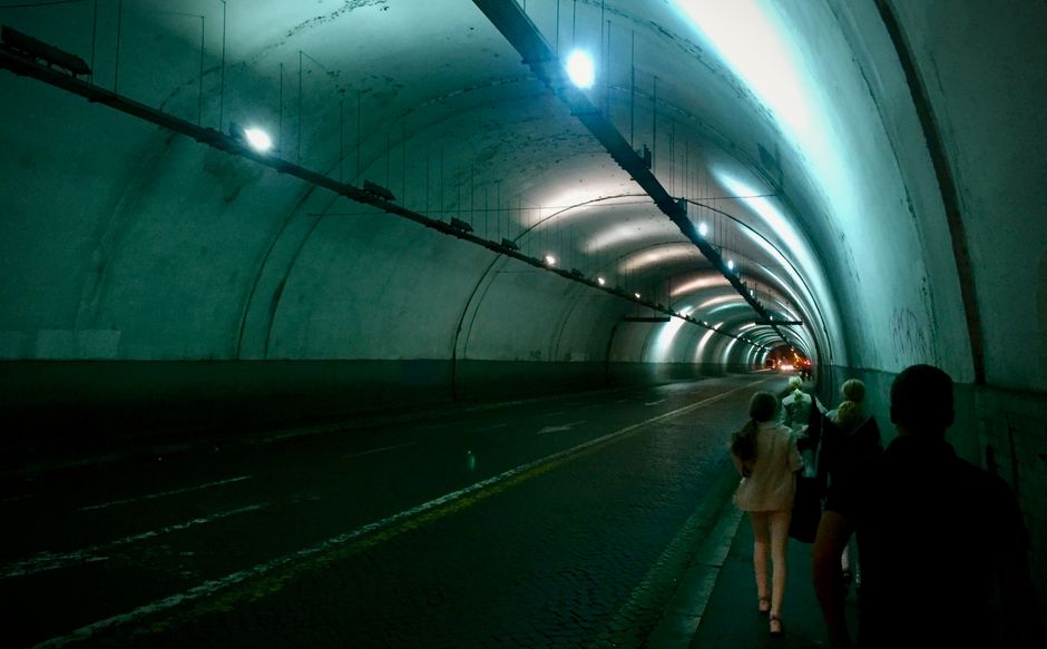 Túnel iluminado en Roma, con rayos de luz y ambiente de exploración urbana.