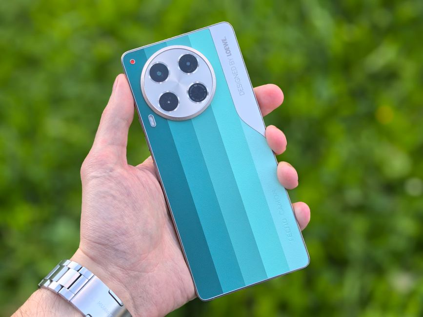 Primer plano de una mano que sostiene un teléfono inteligente moderno con un elegante diseño verde, al aire libre.