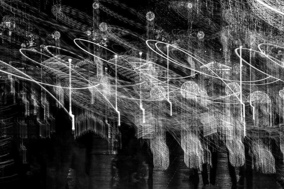 Imagen abstracta creativa en blanco y negro que muestra trazos de luz dinámicos y desenfoque de movimiento.