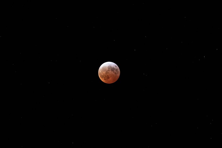 Una vista impresionante de un eclipse lunar rodeado de estrellas sobre Venado, México.