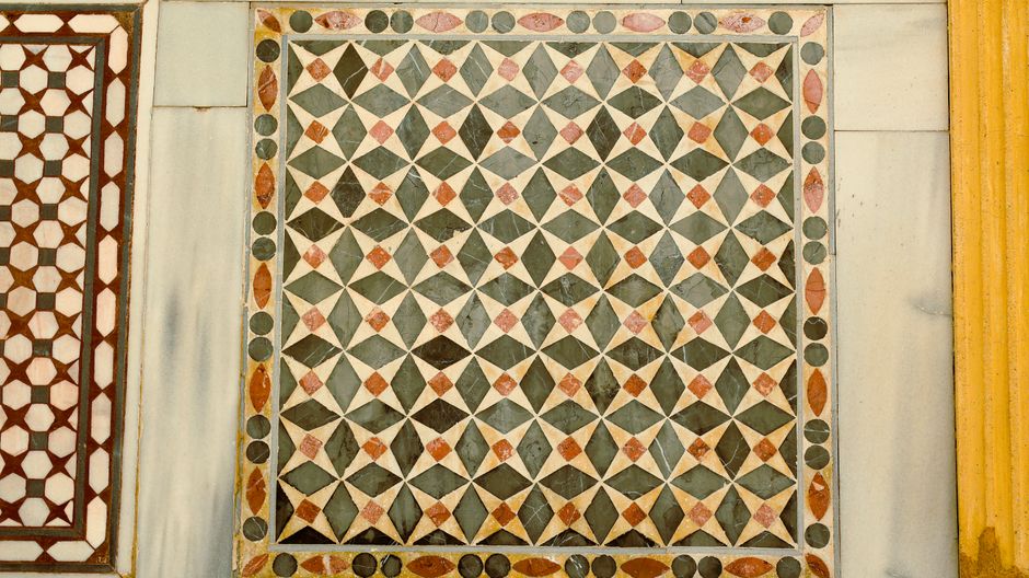 Imagen detallada de un patrón de mosaico geométrico en una pared histórica.