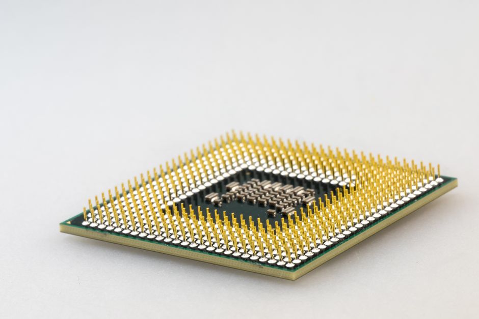 Un primer plano detallado de un microchip de CPU que muestra sus intrincados pines dorados y tecnología.