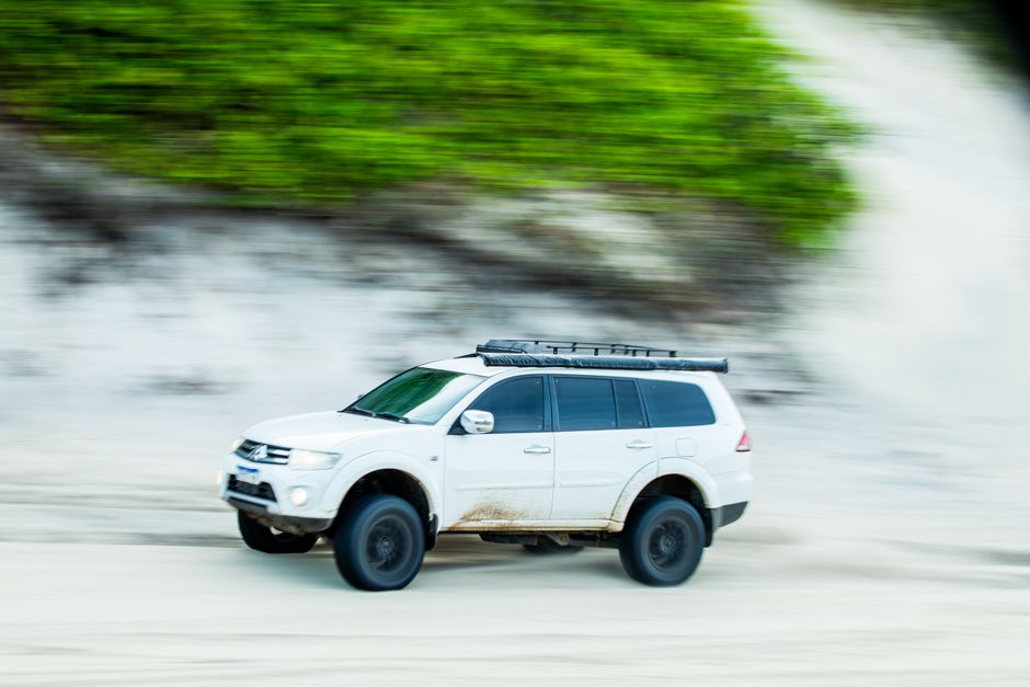 Un SUV Mitsubishi conduce rápidamente por las playas de arena de Baía Formosa, RN, Brasil.