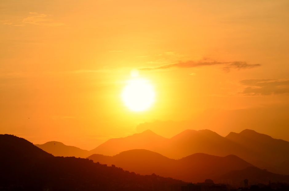 Impresionante atardecer sobre las montañas de Rio de Janeiro, capturando los vibrantes tonos dorados y siluetas.