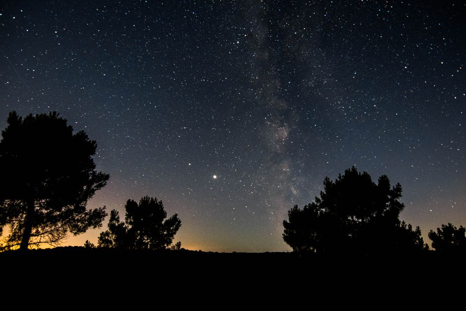Explora el cautivador cosmos y la Vía Láctea bajo una noche estrellada en el pintoresco campo de Francia.