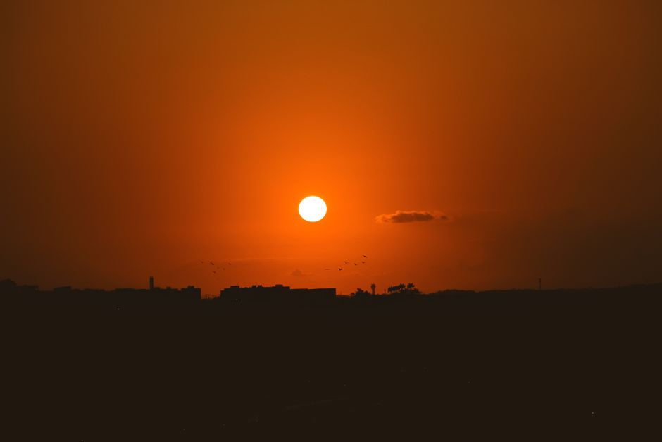 Impresionante atardecer naranja con un horizonte en silueta que crea una atmósfera serena y tranquila.