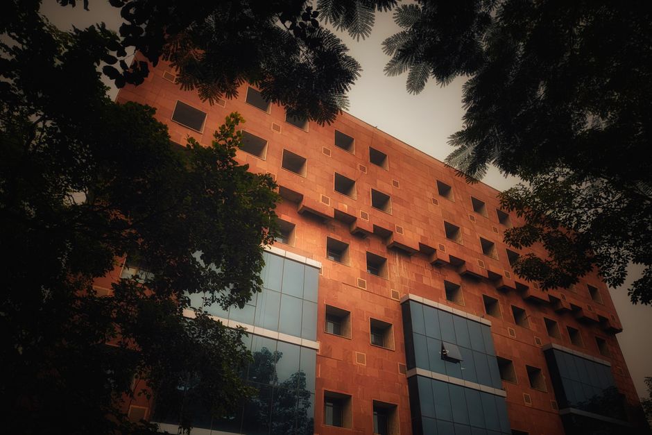 Una fachada arquitectónica única con patrones geométricos rodeada de árboles.