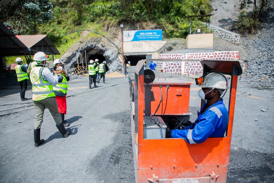 Trabajadores en una mina al aire libre con especial atención a la seguridad del transporte ferroviario.