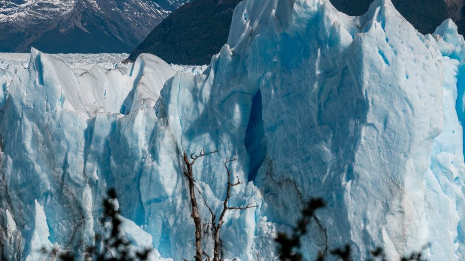 Impresionante vista de un gran glaciar con picos helados y un fondo montañoso escarpado.