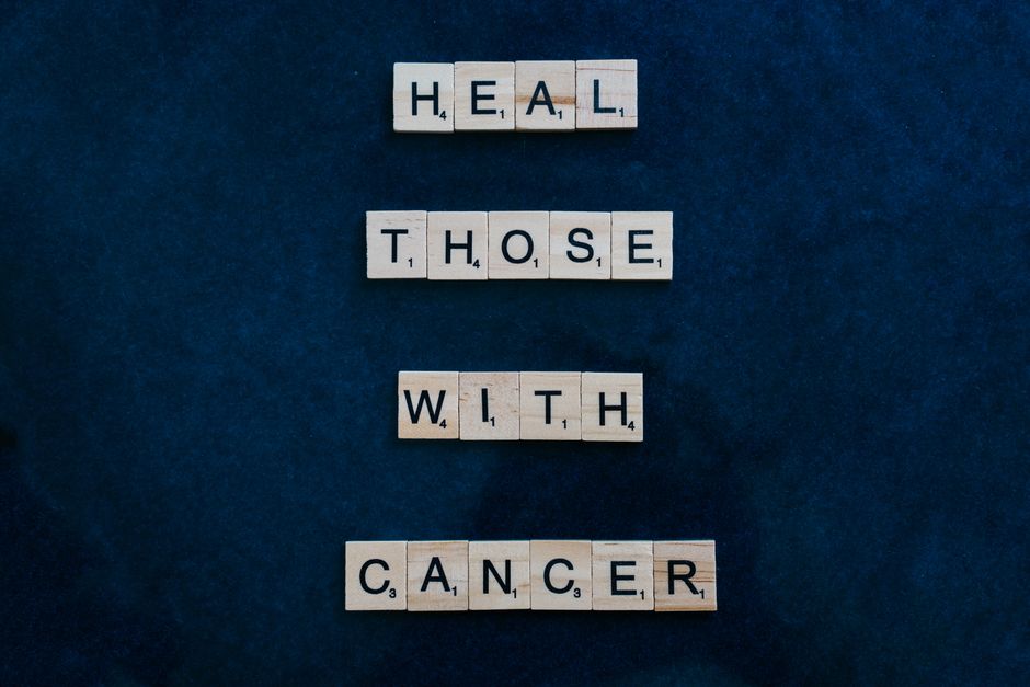 Las fichas de Scrabble forman un mensaje de concienciación sobre el cáncer sobre un fondo azul oscuro.