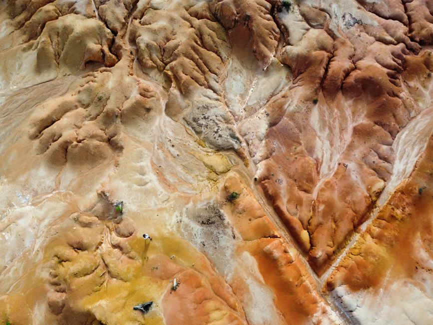 Impresionante toma aérea de un paisaje desértico texturizado con colores vibrantes y formaciones únicas.