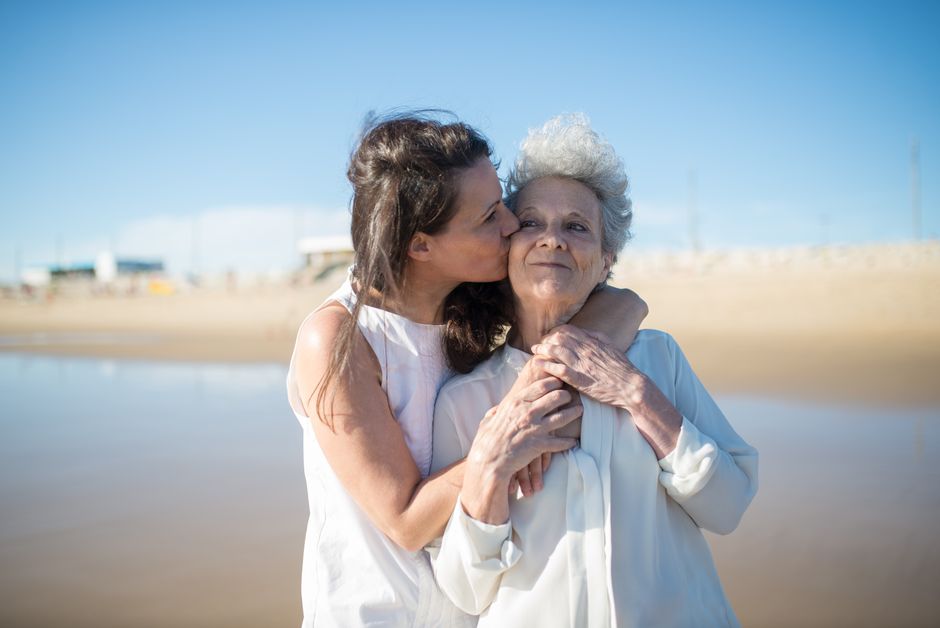 Un momento conmovedor de una hija besando a su madre en una soleada playa portuguesa.