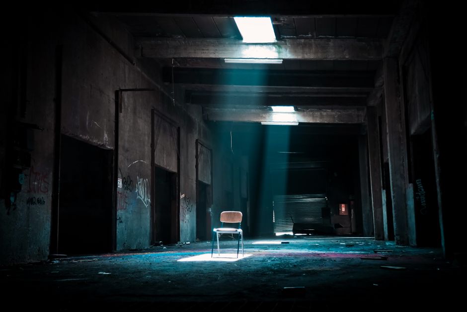 Silla En Lugar Abandonado Con Un Foco Que Viene Del Exterior