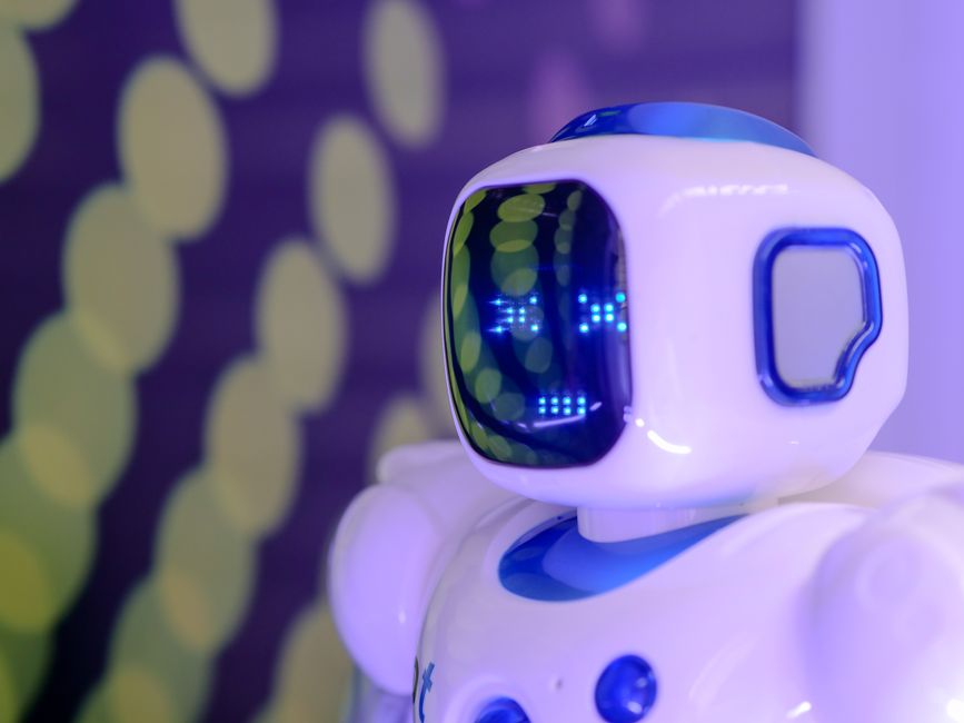 Primer plano de un robot humanoide futurista con una pantalla luminosa en un entorno moderno.
