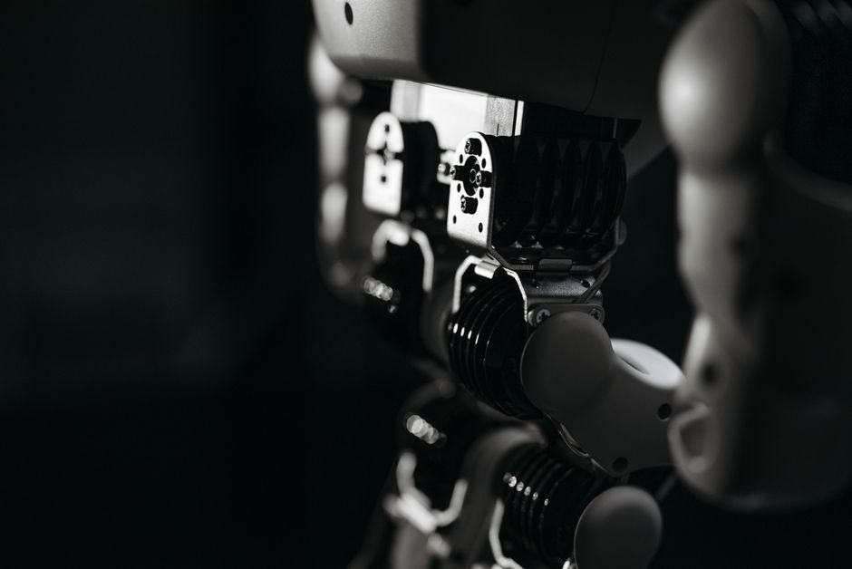 Primer plano detallado de los componentes mecánicos de un robot, enfatizado por una iluminación de estudio ambiental.