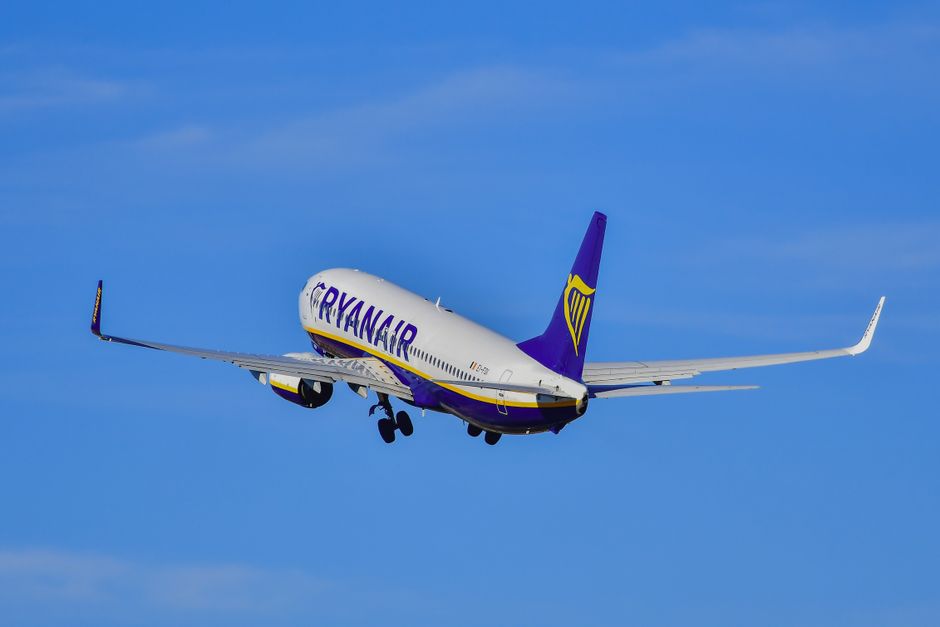 Un avión de Ryanair asciende en un cielo despejado, mostrando la emoción de la aviación y los viajes.