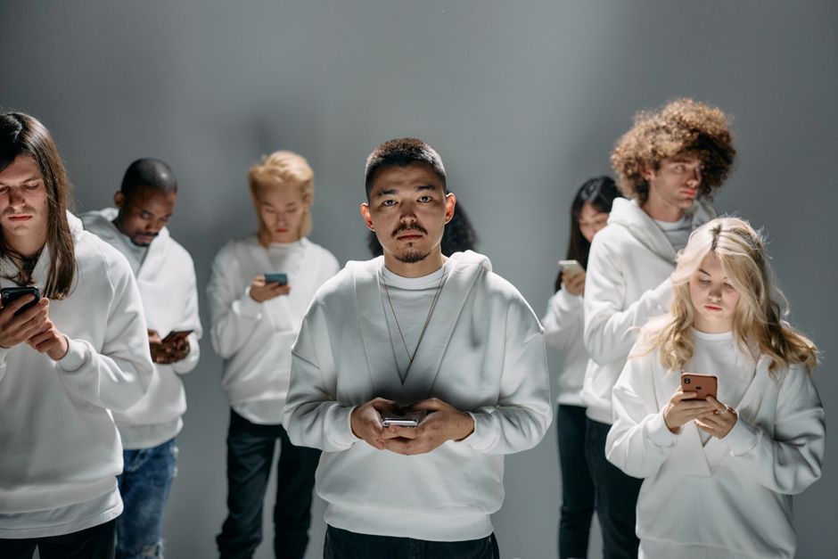 Un grupo diverso de adultos interactuando con smartphones, mostrando conexión social en medio del aislamiento.