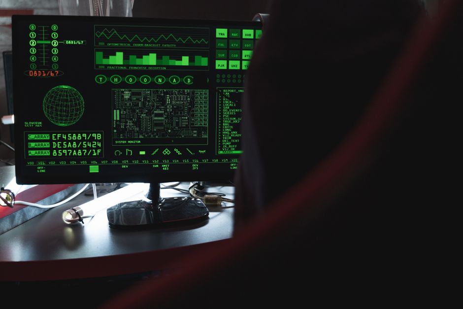Vista de un monitor de ordenador que muestra código de seguridad digital verde en un entorno interior.