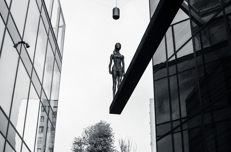 Una sorprendente escultura de bronce elevada entre edificios modernos en un paisaje urbano.