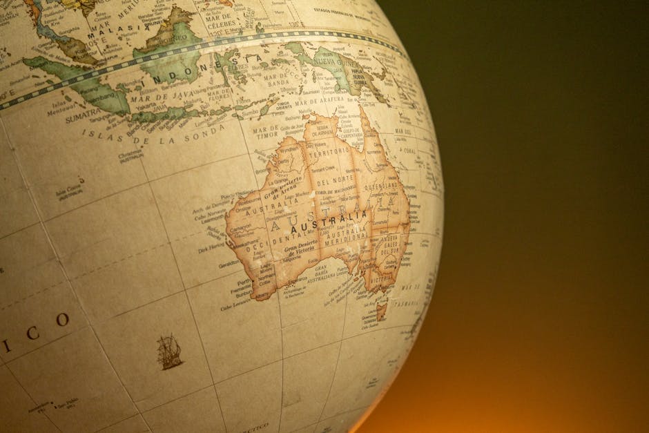 Un primer plano de un globo terráqueo antiguo que muestra Australia e Indonesia sobre un fondo cálido.