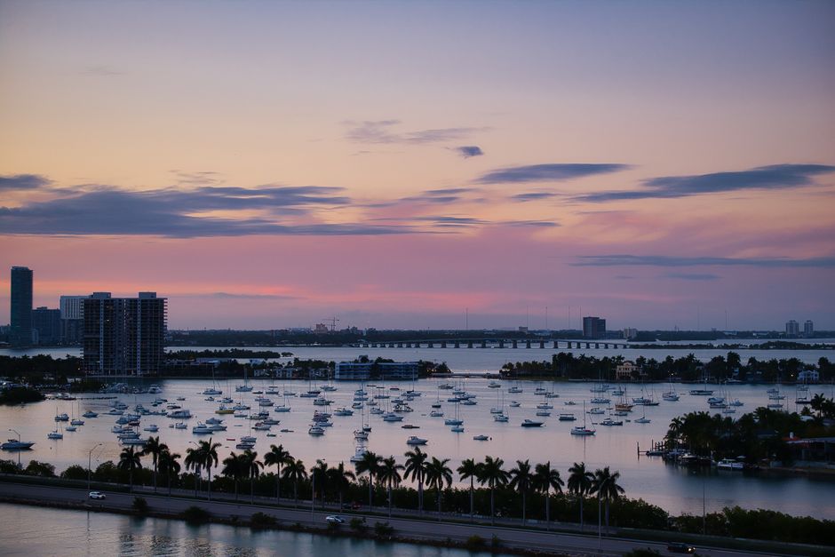 Vista aérea del puerto de Miami con barcos y el horizonte durante el crepúsculo.