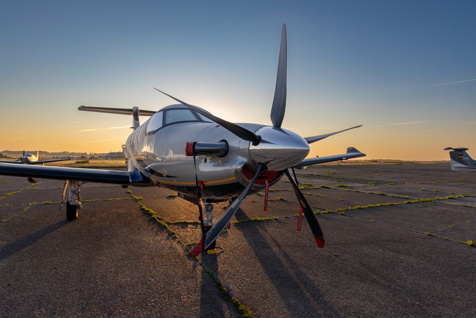 Un elegante avión de hélice aparcado en la pista al atardecer en el Aeropuerto de Sylt, Alemania.