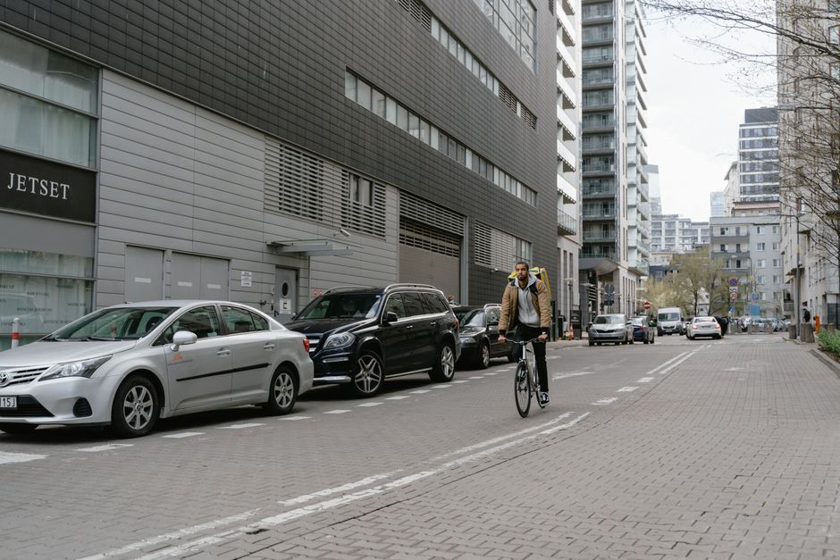 Un mensajero en bicicleta entregando comida en una bulliciosa calle de la ciudad, mostrando la logística urbana moderna.