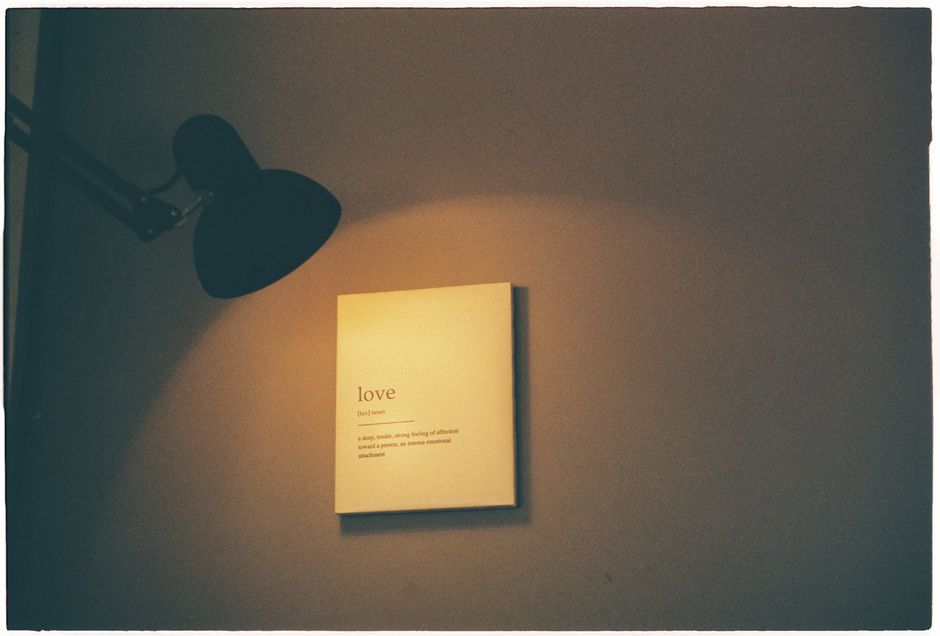 Una habitación iluminada cálidamente que muestra un tablero con la definición de amor iluminado por una lámpara.
