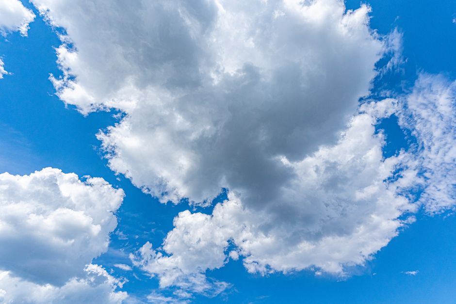 Una vista impresionante de nubes cúmulos esponjadas contra un brillante cielo azul, perfecta para temas de naturaleza.