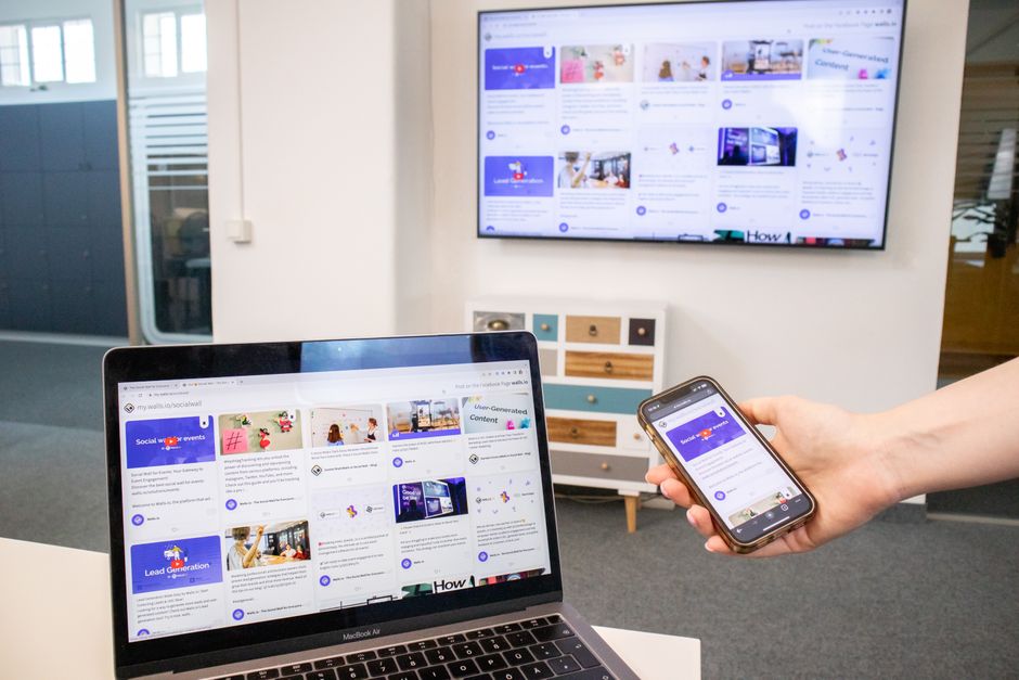 Dispositivos digitales, incluyendo un portátil, teléfono y televisor en un entorno de oficina moderno que muestra la sincronización de contenidos.