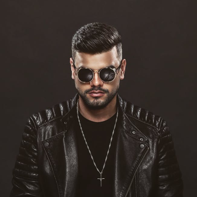 Fotografía De Estudio De Un Hombre Con Barba Que Viste Una Chaqueta De Cuero Negra Y Gafas De Sol