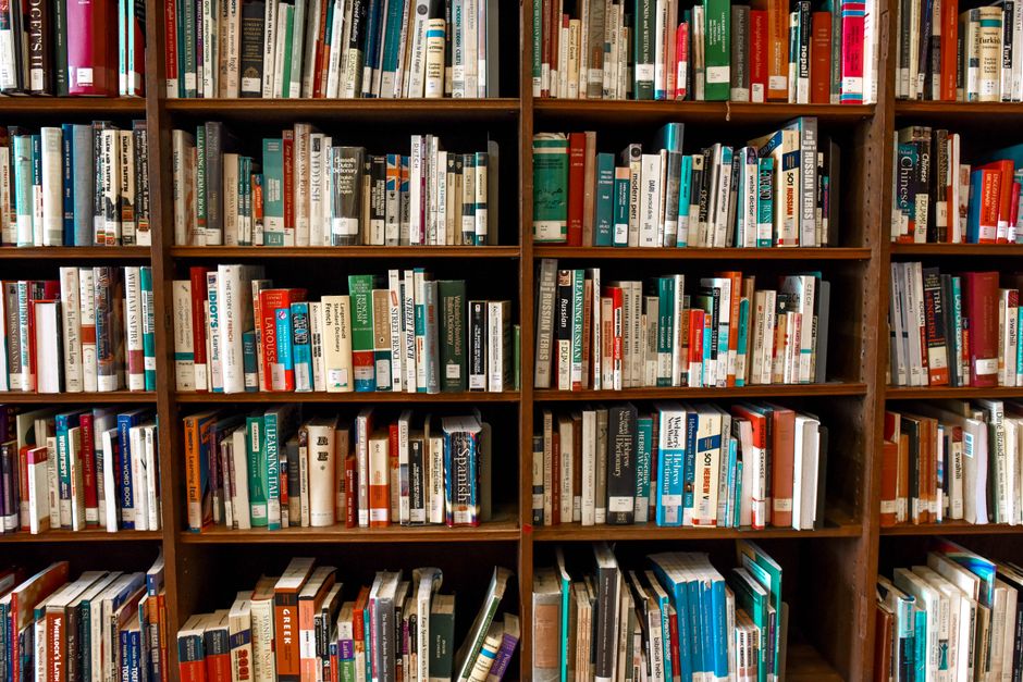 Escena vibrante de biblioteca con estanterías de madera llenas de varios libros.