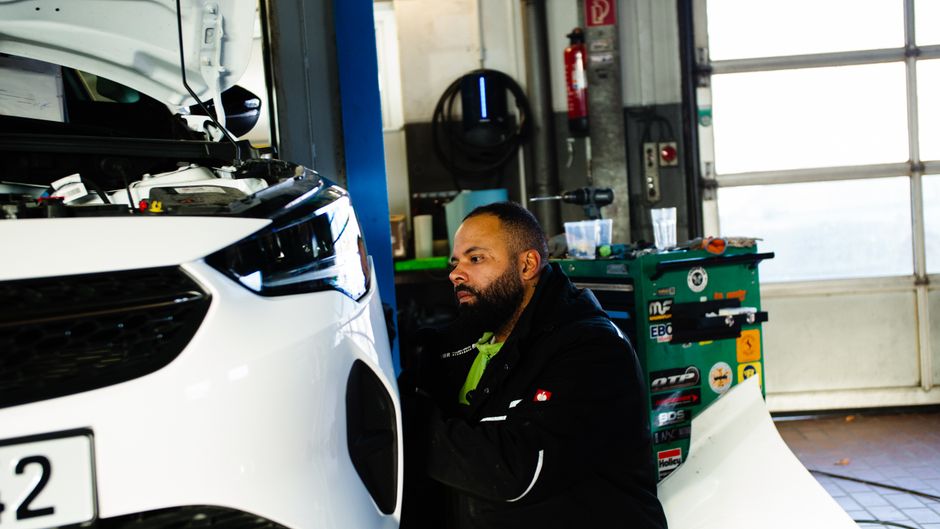 Mecánico trabajando en un motor de automóvil en un taller moderno en Gladbeck, NRW, Alemania.