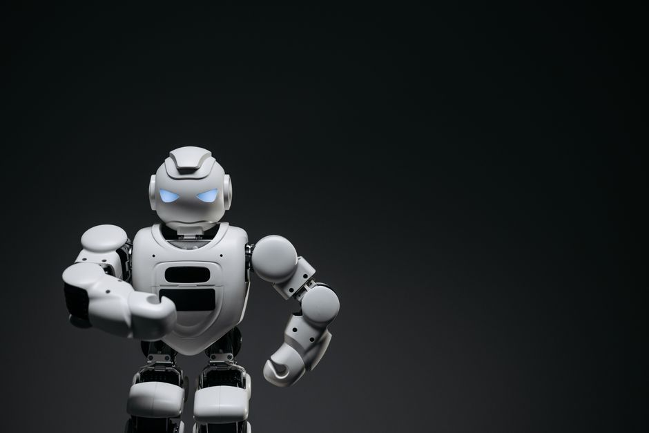 Un robot blanco elegante que exhibe tecnología de robótica moderna sobre un fondo oscuro.