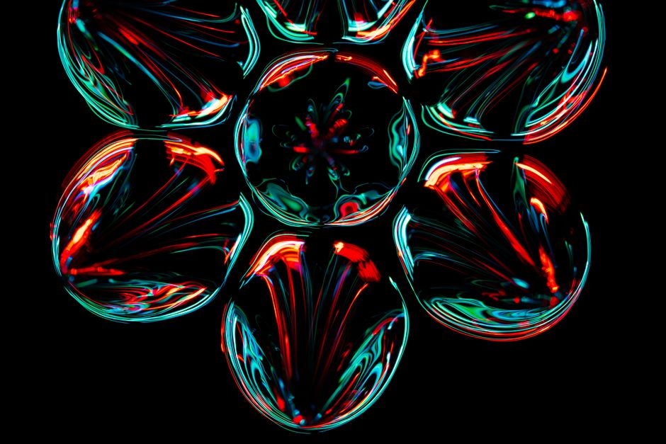Patrón fractal colorido con efectos luminosos sobre un fondo negro, creando un diseño abstracto vibrante.