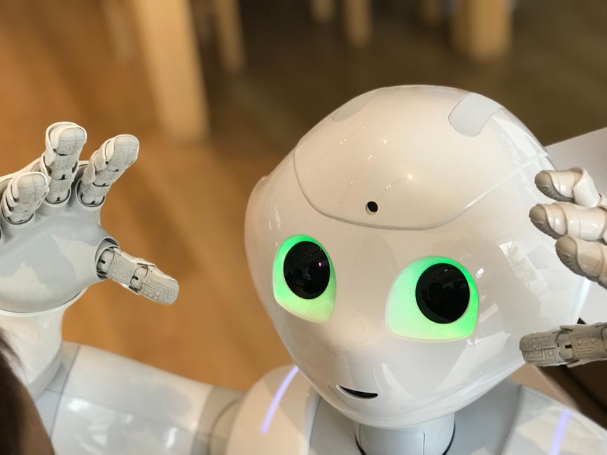 Un robot humanoide futurista con ojos verdes brillantes en un entorno moderno.
