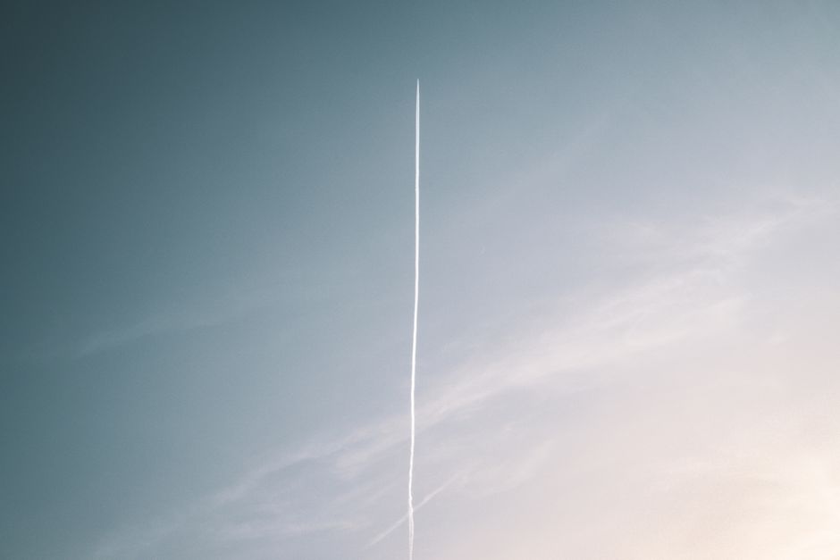 Foto minimalista de una sola estela atravesando un cielo azul claro, simbolizando viaje y libertad.
